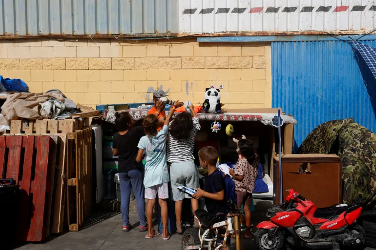 Migrantbarn tar leker i et industriområde, etter massekryssingen av migranter fra Marokko, i Ceuta, Spania, 21. september 2026. REUTERS/Jon Nazca TPX DAGENS BILDER