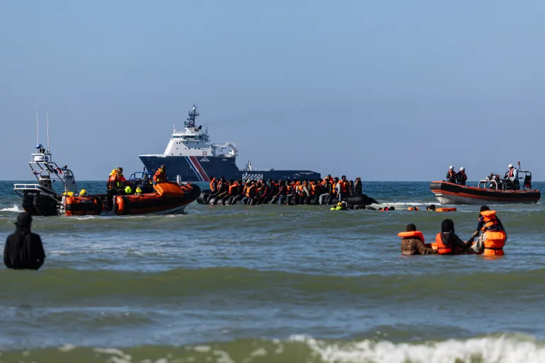 Migranter prøver å gå om bord i en smuglerbåt utenfor stranden i Equihen-Plage, Nord-Frankrike, 23. september 2026.