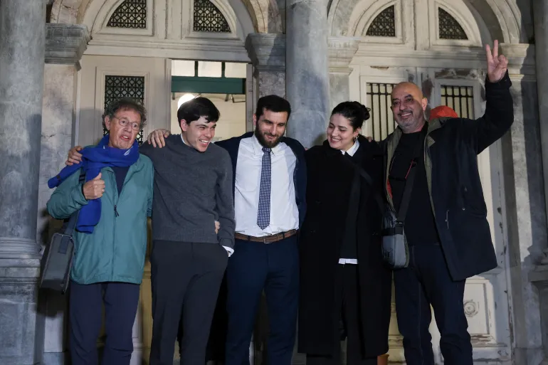Sean Binder og Sarah Mardini feirer sammen med andre hjelpearbeidere involvert i flyktningredninger, etter dommen i rettssaken deres i byen Mytilene på øya Lesbos, Hellas, 15. januar 2026. REUTERS/Elias Marcou