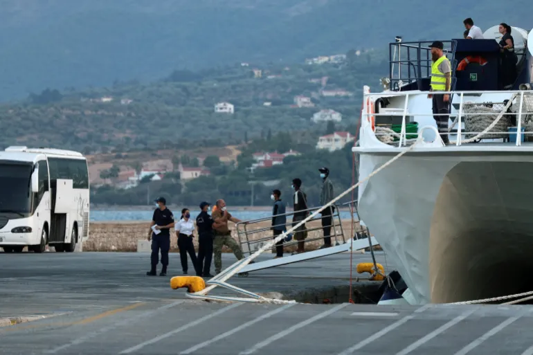 Migranter overført fra Kreta ankommer havnen i Mytilene før de blir overført til den midlertidige Kara Tepe flyktningleiren, som en del av arbeidet med å lette presset på Kreta etter en økning i migrantankomster sjøveien, på øya Lesbos, Hellas, 23. august 2026. REUTERS/Elias Marcou